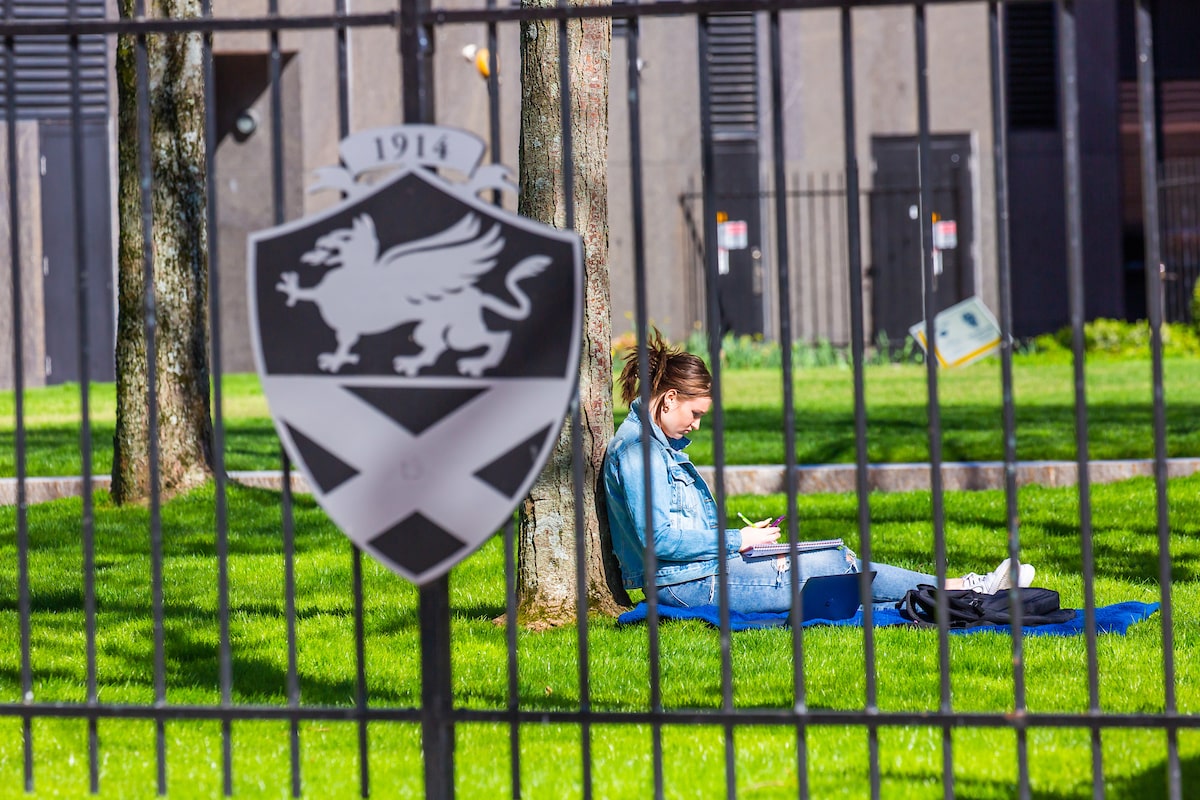 Student studying on lawn in Gaebe Commons