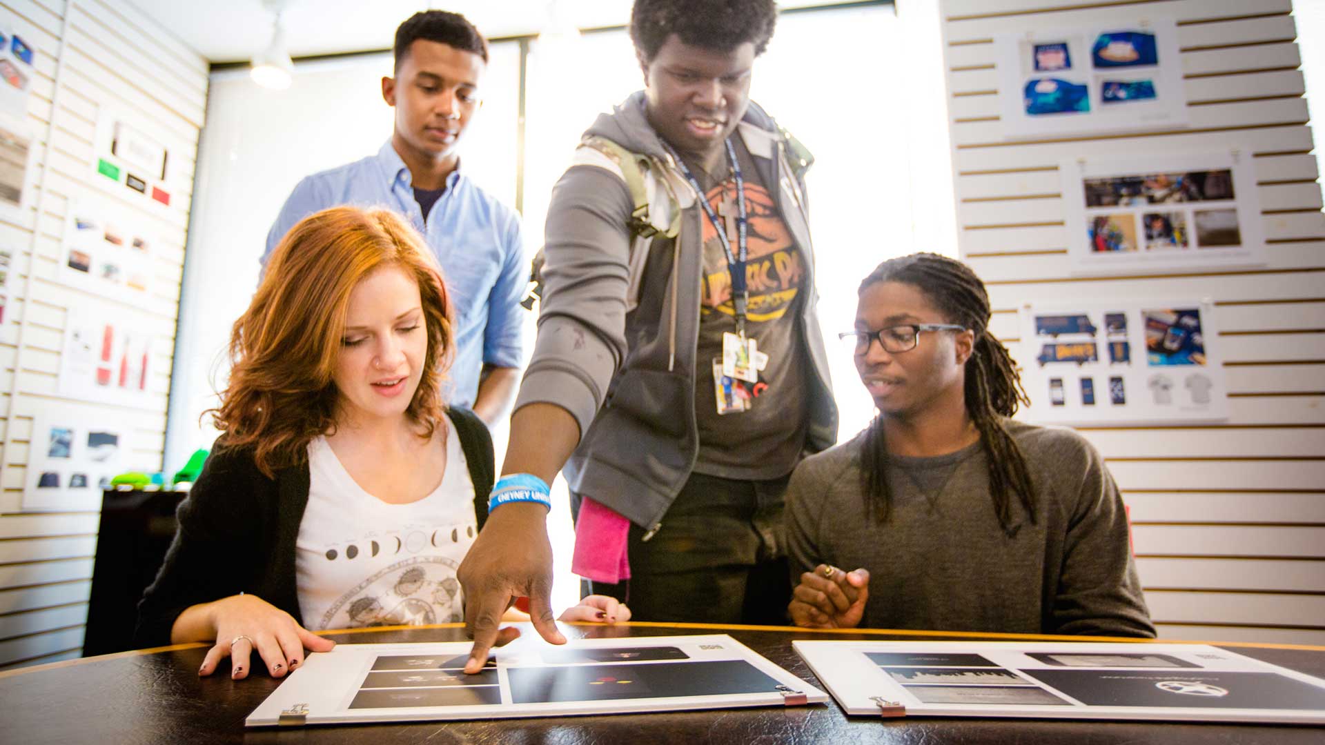 trio of students reviewing graphic design examples