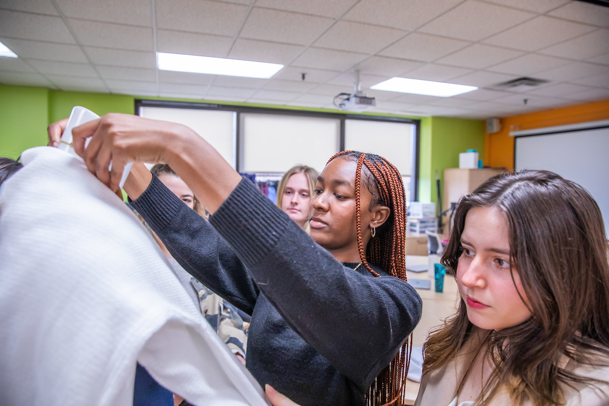 Two students working with fabric and a mannequin