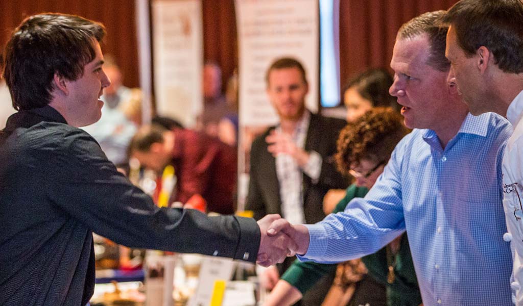 Enjoy the opportunity to meet with hundreds of employers looking specifically to work with JWU students at a career fair Student shaking hands at a JWU career fair