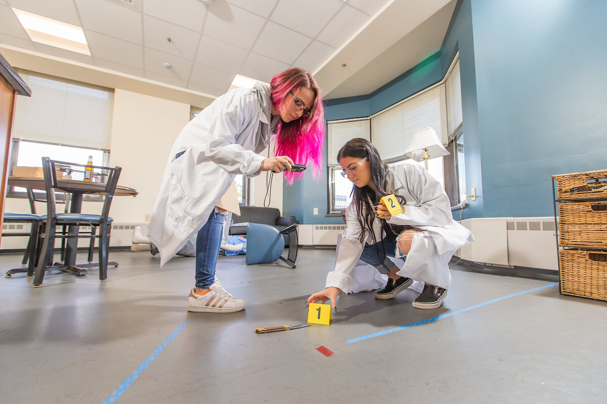 Students inspecting a mock crime scene