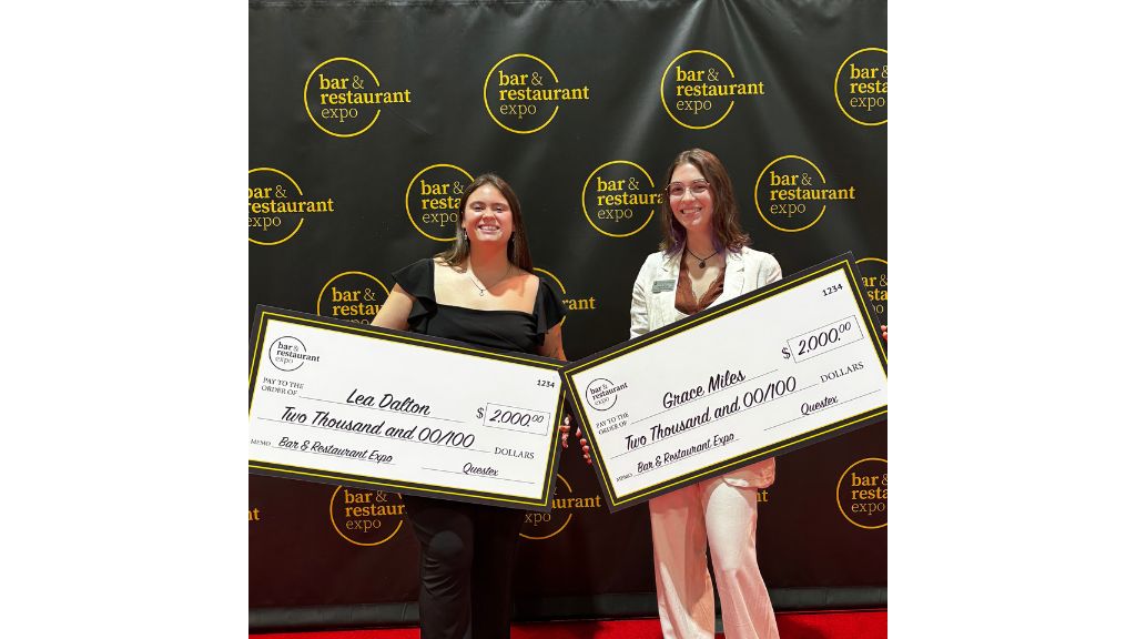 photo of Lea Dalton '26 & Grace Miles '26 holding large checks