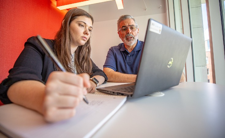 Student and professor using a laptop